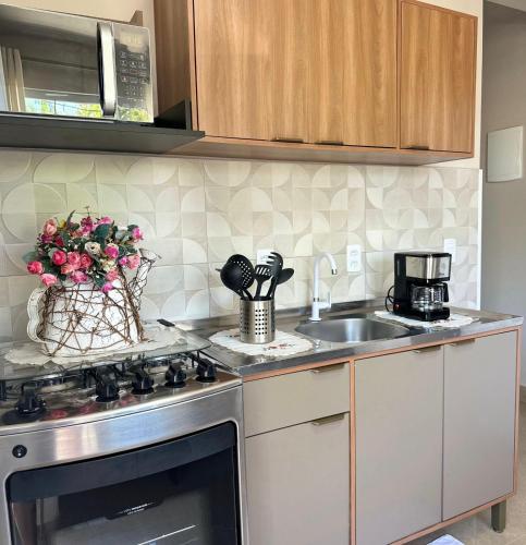 a kitchen with a stove and a sink at Flet dos sonhos in Florianópolis