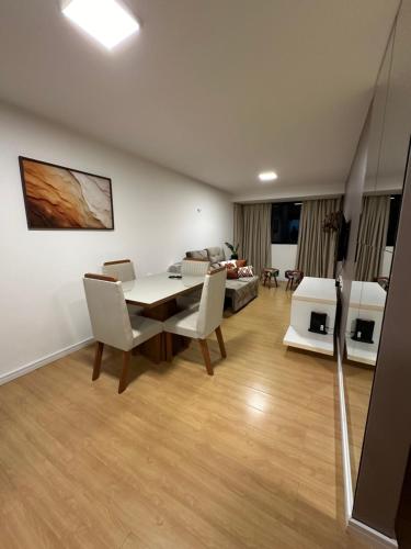 a living room with a table and chairs and a couch at Apartamento Sua Casa em João Pessoa in João Pessoa