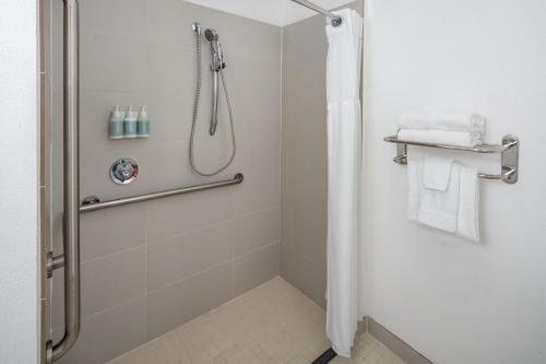 a bathroom with a shower with white towels at Residence Inn Orlando Convention Center in Orlando