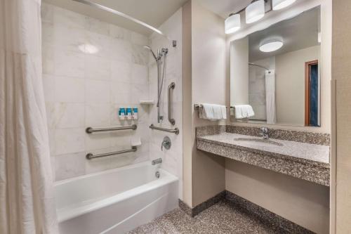 a bathroom with a tub and a shower and a sink at Drury Plaza Hotel Valdosta in Valdosta