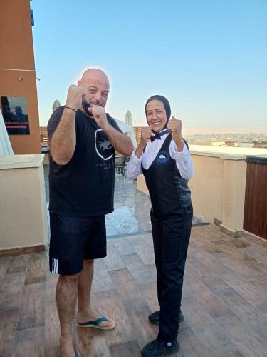 two men are posing for a picture while brushing at Pyramids Sunshine View in Cairo