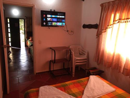 a room with beds and a television on the wall at Villa Liliana Lodge Mesa de los Santos in Los Santos