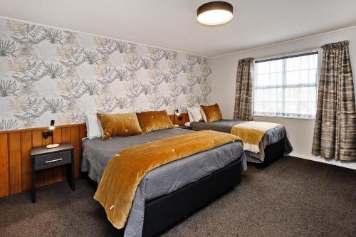 a hotel room with two beds and a window at Balmoral Lodge Motel in Invercargill
