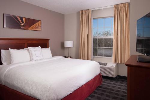 a hotel room with a bed and a large window at TownePlace Suites The Villages in The Villages