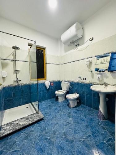a bathroom with two toilets and a shower and a sink at THE DOMI Apartments in Durrës