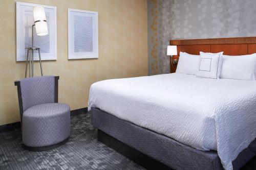 a hotel room with a large bed and a chair at Courtyard by Marriott Lexington North in Lexington