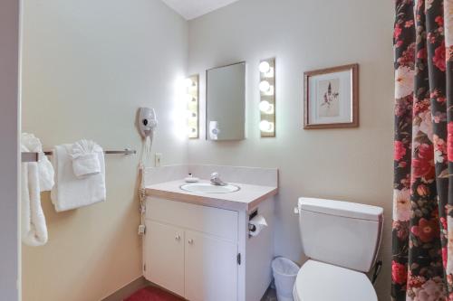 a bathroom with a toilet and a sink and a mirror at Lincoln City Condo Pool Access, Walk to Beach! in Lincoln City