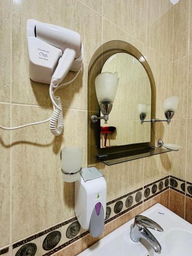 a blow dryer on a wall next to a bathroom sink at THE DOMI Apartments in Durrës