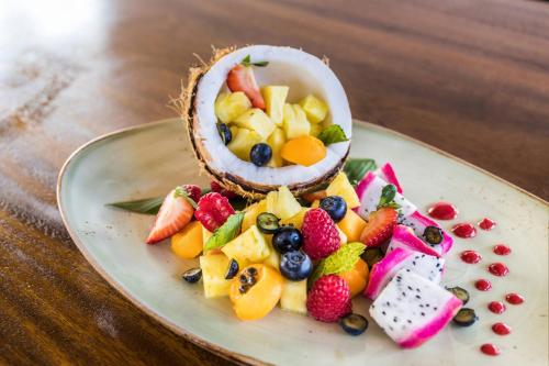 a plate with a fruit salad on a table at Koloa Landing Resort at Po'ipu, Autograph Collection in Koloa