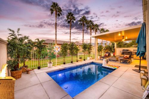 a swimming pool in a backyard with palm trees at Music Lovers Paradise 7 Bed Pool Home and Game Room in Indio