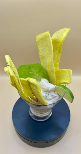 a glass bowl filled with banana leaves and whipped cream at Akwaba Lodge in The Gap