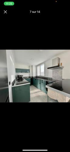 une grande cuisine avec des armoires bleues et des comptoirs verts dans l'établissement Appartement Élégant avec Parking Gratuit, à Marseille