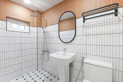 a bathroom with a sink and a toilet and a mirror at lyrical Hotel Busan Yeongdo in Busan