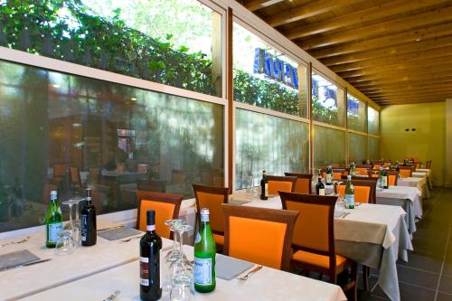 a dining room with tables and bottles of wine at Hotel Mosca in Monza