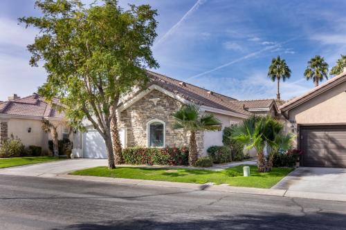 a house with palm trees and a driveway at Music Lovers Paradise 7 Bed Pool Home and Game Room in Indio