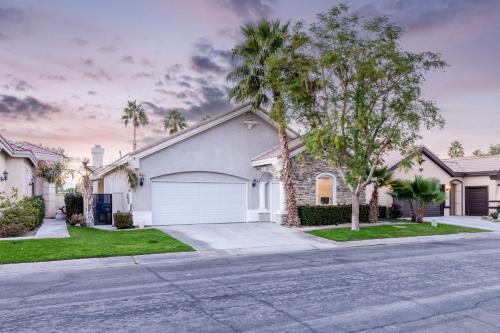 a house on a street with palm trees at Music Lovers Paradise 7 Bed Pool Home and Game Room in Indio