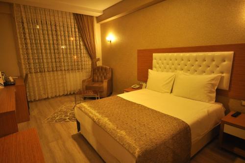 カイセリにあるブパ ホテルのベッドと椅子付きのホテルルーム