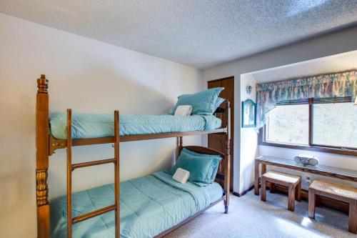 two bunk beds in a room with a window at Snowater Condo 38 - A great mountain retreat in Glacier