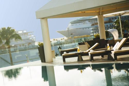 a pool with chairs and a cruise ship in the background at Renaissance Wind Creek Aruba Resort in Oranjestad