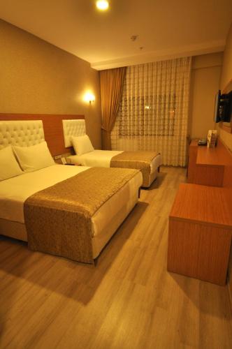 a hotel room with two beds and a window at Bupa Hotel in Kayseri