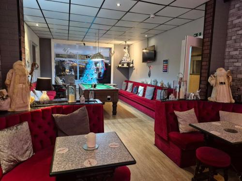a bar with red couches and a christmas tree in a room at MyRoomz Silver Strand Hotel in Blackpool