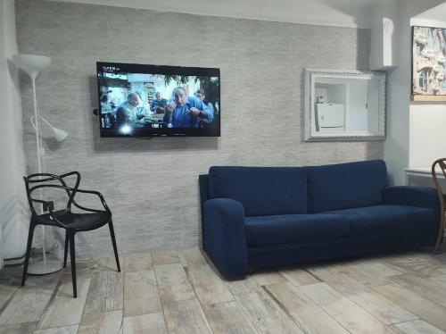 ein Wohnzimmer mit einem blauen Sofa und einem Flachbild-TV in der Unterkunft Downtown Apartment with Private Yard YR1 in Thessaloniki