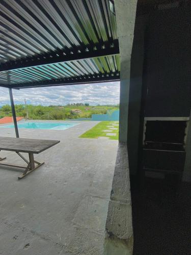 a picnic table under a pavilion with a view of a pool at Espaço Mattigor in Caçapava