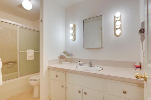 a bathroom with a sink and a toilet and a mirror at Cozy Oregon Resort Condo - Steps to Lincoln Beach! in Lincoln City
