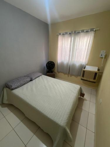 Un dormitorio pequeño con una cama y una ventana. en Prive 3 quartos proximo a praia, en Paulista