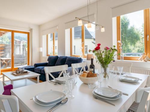 a dining room and living room with a white table and chairs at Bachwinkl in Maria Alm am Steinernen Meer