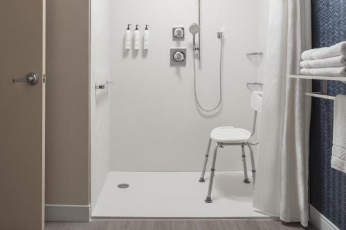 a shower with a stool in a bathroom at Fairfield Inn & Suites by Marriott Lexington Georgetown/College Inn in Georgetown