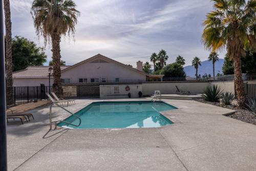 a swimming pool with two chairs and a house at Music Lovers Paradise 7 Bed Pool Home and Game Room in Indio