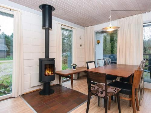 a fireplace in a dining room with a table and a wood stove at 6 person holiday home in Herning in Herning