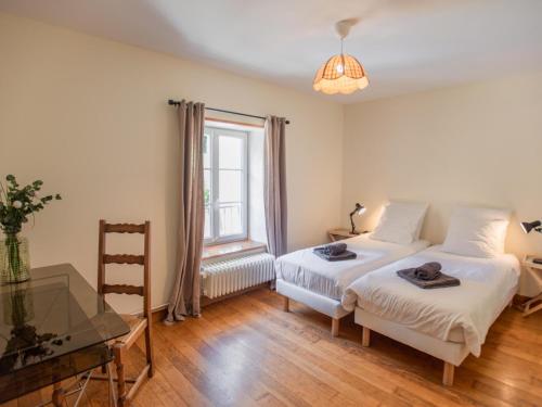 a bedroom with two beds and a desk and a window at Gite du Moulin in Guignicourt-sur-Vence
