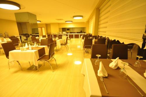 a dining room with white tables and chairs at Bupa Hotel in Kayseri