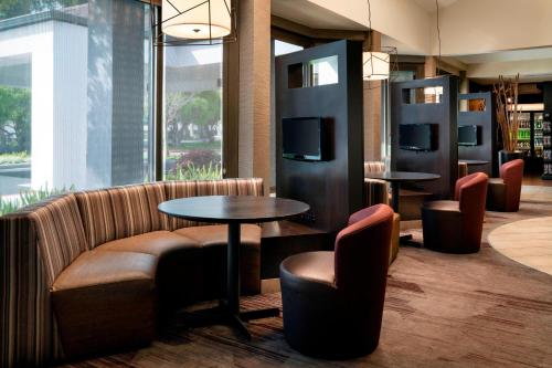 a lobby with a couch and tables and chairs at Courtyard by Marriott San Francisco Airport in San Bruno
