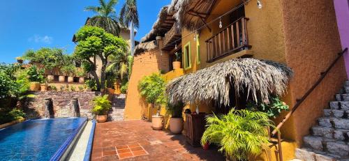 a house with a swimming pool next to a building at Suites Marid in Zihuatanejo