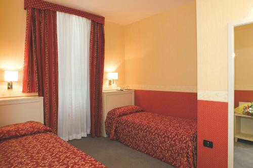 Habitación de hotel con 2 camas y ventana en Hotel Mosca, en Monza