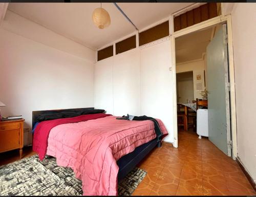 Un dormitorio con una cama con una manta rosa. en Departamento 2 ambientes, en Mar del Plata