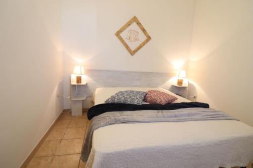 a bedroom with two beds and two lamps on the wall at Casa Regina Residence Torre Santo Stefano in Otranto 3 places in Alimini