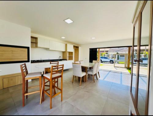 a kitchen and dining room with a table and chairs at Casa Atantida Sul in Osório