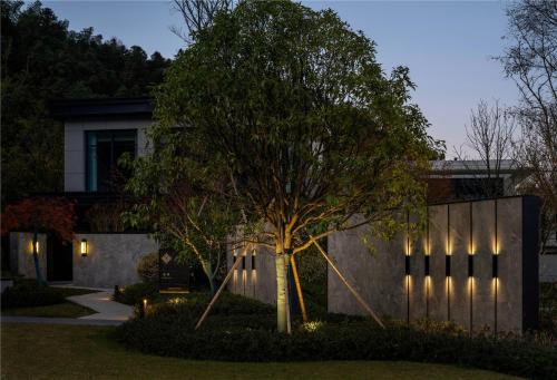 a house with a tree in front of a building at Yibo Jinling Hotel Moganshan in Huzhou