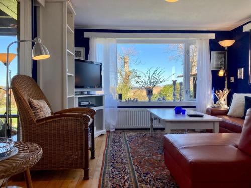a living room with a couch and a tv at 6 pers House Marijke with winter garden and direct access to the Lauwersmeer in Anjum