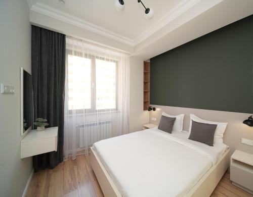 埃里温Modern apartments in the heart of Yerevan by Sweet Home的卧室里有一张白色的大床和一扇窗户