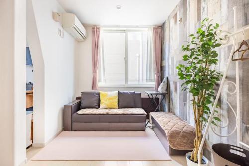 a living room with a couch and a window at Pet Friendly 7min to Haneda Quick Access to Shinagawa and Tokyo in Tokyo