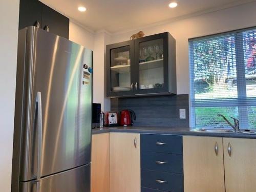 a kitchen with a stainless steel refrigerator and cabinets at The Garden Room by Waiheke Pure in Waiheke Island