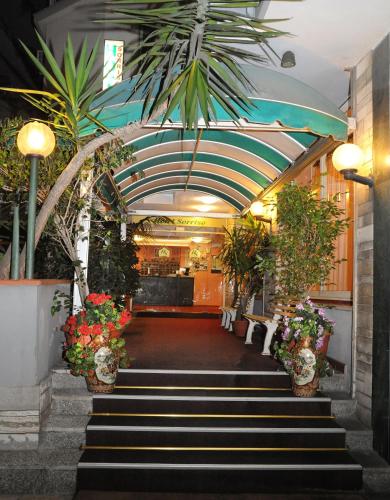 a lobby with stairs with flowers and plants at Hotel Sorriso in Sanremo