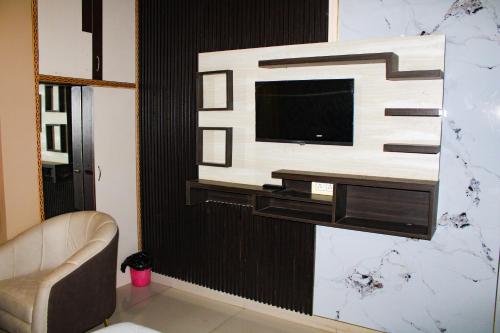 a living room with a tv on a wall at Sangam Resort, pilani in Chirāwa