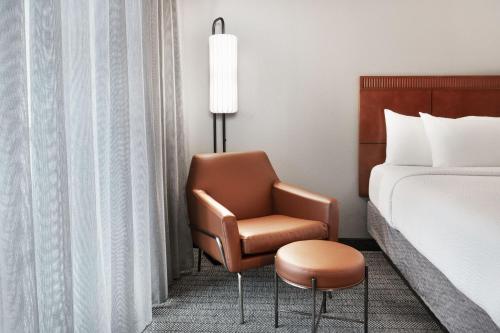 a hotel room with a chair and a bed at Courtyard by Marriott Memphis Airport in Memphis