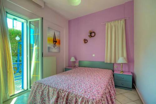 a bedroom with a bed with purple walls and a window at bbq, backyard, Of Amoudara, full Kitchen, parking-3 in Ayía Marína